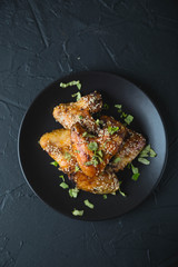 Crispy chicken wings with sesame seeds and chopped herbs