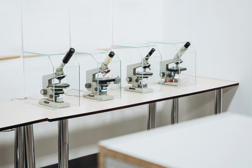 Four microcops in protective boxes on the table. Microbiology, study, science