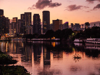 Naklejka premium Skyline of Makati City reflecting in the Pasig River in Metro Manila, Philippines while sunrise