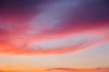 Obraz premium Attractive red vivid clouds illuminated by the beams of the sun.