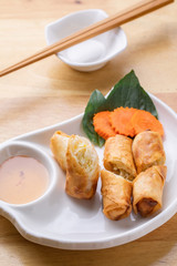 Deep fried spring rolls on white plane.