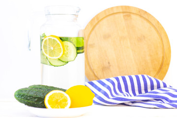 Health care, fitness, healthy eating concept. Fresh cool lemon cucumber drink with water, cocktail, detox drink, lemonade in a glass jug and a glass.
