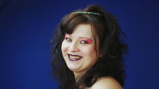 The girl laughs.Dark matted hair with beads.Brown eyes and black lips.