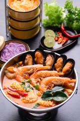 Thai Noodles and Tom Yum seafood, Shrimp, Squid, Mussel with Thai herbs in pot.