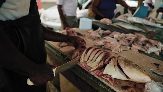 Local butchering a fish on the beach in Tobago, West indies.