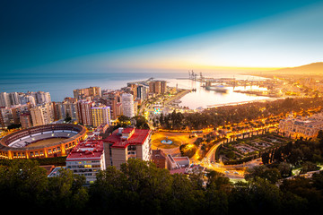 View of the city of Malaga, with the bullring and the Port on sunset.