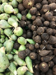 Fresh green and brown radishes on the market
