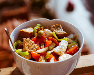 The first greek salad of 2020.Beautiful red tomatoes,green peppers , white onion , feta cheese and olives lit by the midday sun