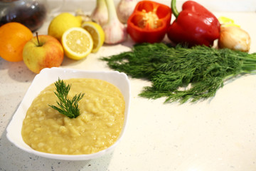 Close-up appetizing lentil porridge 
in a white dish on a light kitchen countertop. Top down. Healthy eating concept. Lean vegetarian food