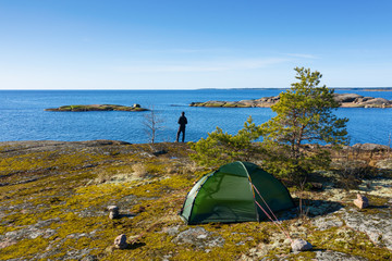 A man with a tent on the shore of the Baltic sea.