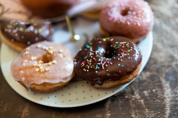 Homemade donuts or doughnuts, with sugar glaze and colored sugared almonds, in a vintage setting.