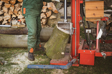 Waldbauern bzw. Waldarbeiter schneiden und verkleinern gefällte Bäume zu Brennholz. Forsttechnik...