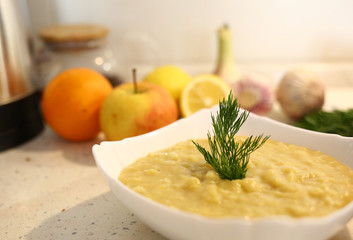 appetizing lentil porridge 
in a white dish, healthy eating background of various fruits and vegetables on a light kitchen countertop. Vegetarians. Lean food