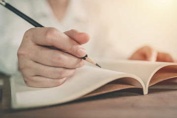 Close up of young business people are writing on paper.