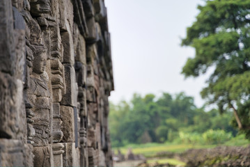 carved figure in the facade of an old stone building of a Hindu temple