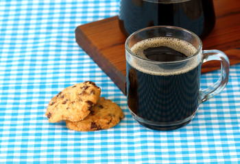 black coffee and chocolate chip cookies on the table
