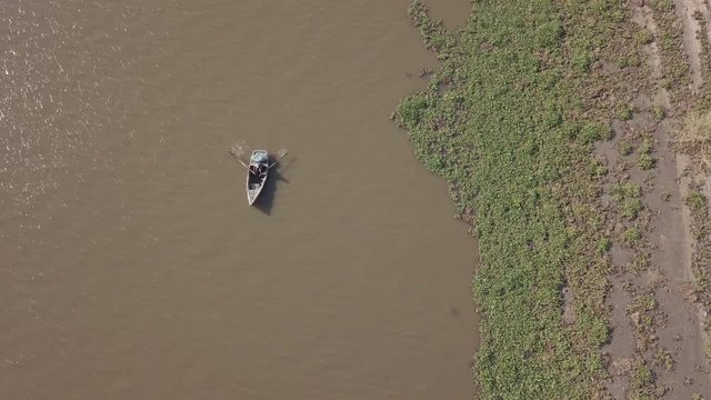Fisherman paddling with nests in his boat on Incomati River, Macaneta Beach, Maputo Province, Mozambique