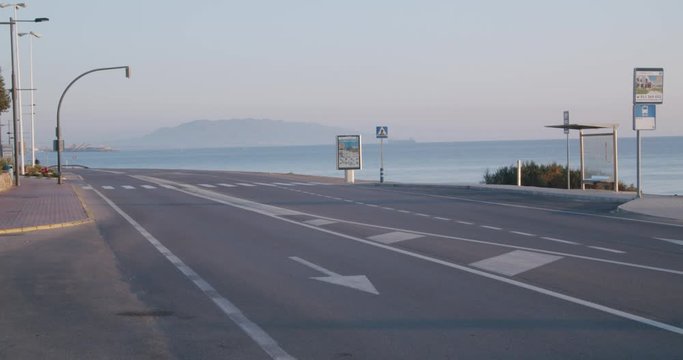 Fluid motion track highway sunrise, motorcycle passing, ocean in distance, Europe