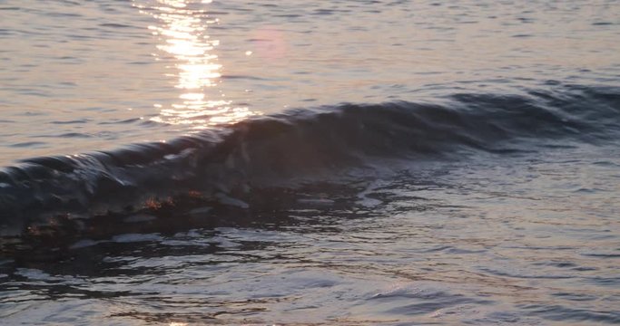 Focused close up small waves crashing, reflection sunrise, Mojacar, Almeria, Spain