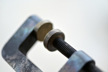 An old screw clamp on dirty background.	