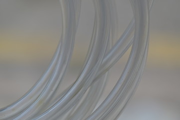 Transparent rubber hoses against a blurry background.