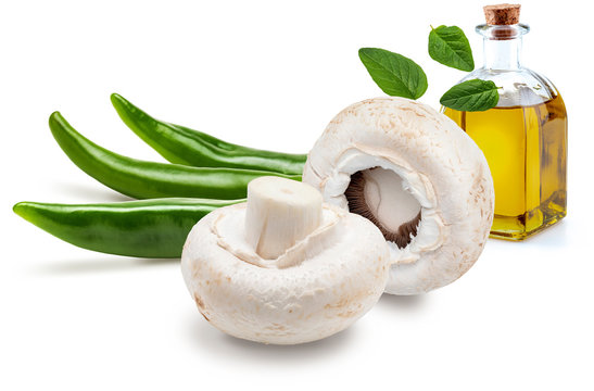 Raw mushrooms, with chilli peppers, green peppers, olive oil and freco oregano leaves (champignon, cut foot, Agaricus Bisporus). Isolated on white background