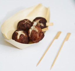 Japanese style snack in wooden cup with pick stick on white isolated background like takoyaki
