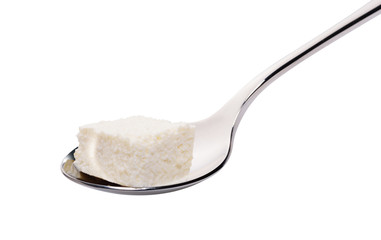 Ricotta cheese cube on the metal spoon. isolated on white.