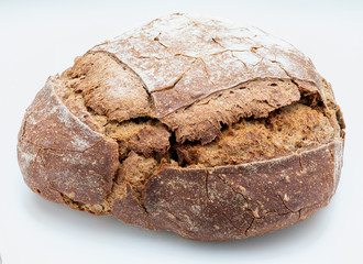 Crispy rustic homemade bread. Side view of whole rye bread. Isolated on white background.