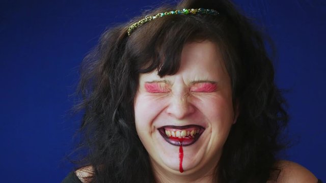 The woman is a witch.Black,matted hair.The red makeup.Crazy laughter.