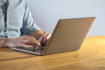 Successful businessman working behind a laptop at home. Blogger man maintains his personal blog on a laptop. Close-up