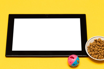 buy pet food and toys online via the app on your tablet, on a yellow background with a copy of the space.
