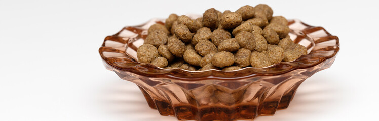 Balls of cat food in a beautiful bowl on a white background