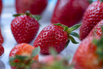 Fresh strawberries lying on the white table, spring time, macro shot
