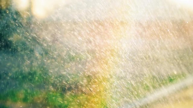 Small drops of water fly and form a beautiful colored rainbow. Slow motion footage.