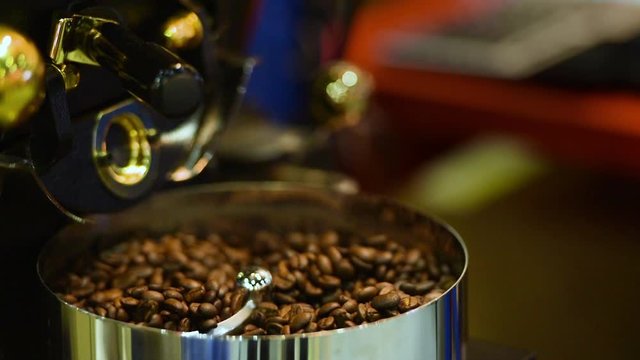 Coffee beans in the auto coffee grinder. Hight Power grinder filled with many roasted coffee beans. industry coffee use automatic machine  for make many fresh drink.