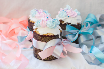 Traditional slavic orthodox easter cake named kulich with white icing, meringue decoration and festive ribbons