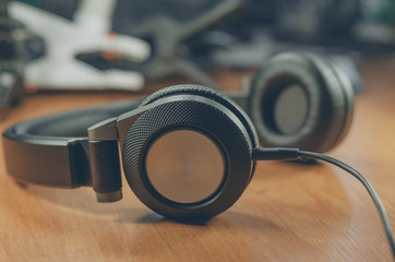 Fototapeta na wymiar Black headphones on wooden table background