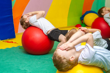 The children of the Europeans five, six years practice in the sports hall in the kindergarten. Healthy sports training. Group kids fitness with stability balls. Development of flexibility, dexterity, 