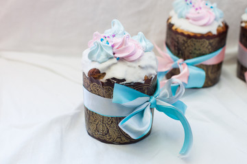 Traditional slavic orthodox easter cake named kulich with white icing, meringue decoration and festive ribbons
