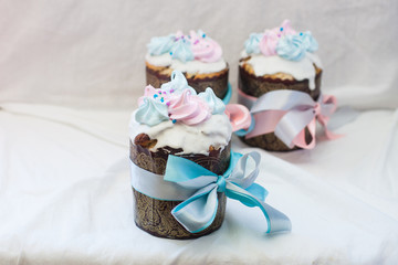 Traditional slavic orthodox easter cake named kulich with white icing, meringue decoration and festive ribbons