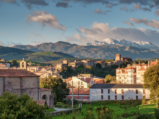 View of the San Vicente de la Barquera cityscape and snowy mountains of the Picos de Europa mountain range in the background