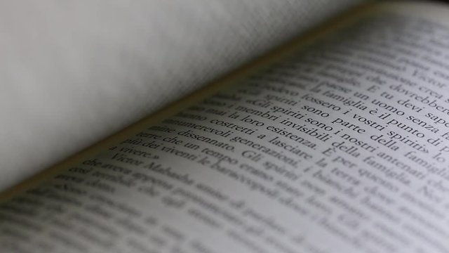 Close up macro of man's hand turning pages of a book