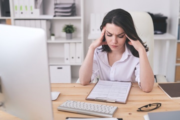 Young serious businesswoman concentrating on learning financial papers