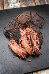 Traditional barbecue wagyu pulled beef offered as top view on a rustic board