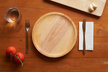 wooden plate and cutlery against a wood background with mediterranean elements