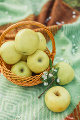 Apples in basket on green tablecloth