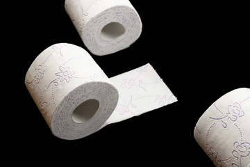Toilet paper holder. Soft tissue roll isolated on black background. Bathroom hygiene concept