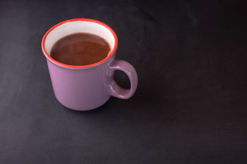 Delicious fragrant hot chocolate in a beautiful cup on a black background.