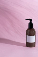 Cosmetic bottle on pink background with shadows mock up photography